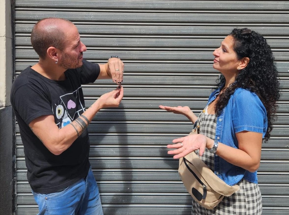 La imagen muestra a dos profesores de LSA del Laboratorio de idiomas parados frente a frente conversando