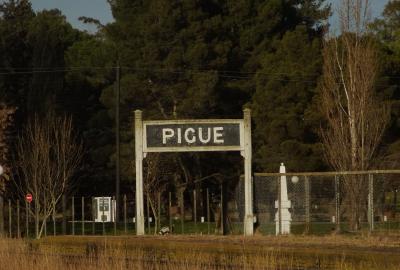 La imagen muestra un cartel de la estación de trenes de la localidad bonaerense de Pigüé, fundada por franceses