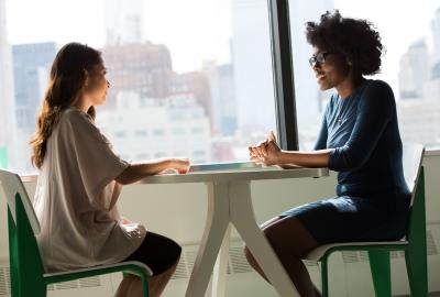 La imagen muestra a dos mujeres charlando