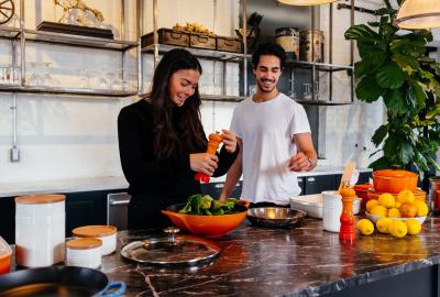 La imagen muestra a un hombre y a una mujer cocinando 