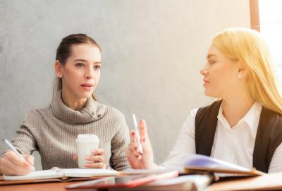La imagen muestra a dos muejres conversando