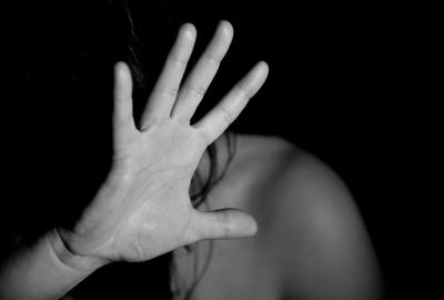 La imagen muestra la mano de una mujer en señal de "no me pegues" 