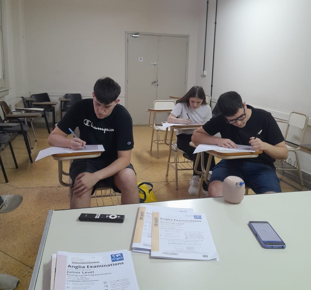 La imagen muestra a los estudianttes realizando el examen escrito