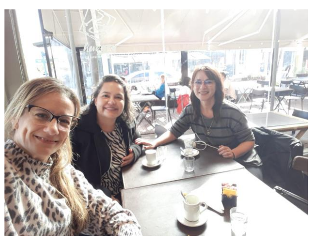 La imagen muestra a las profesoras mencionadas en el artículo sentadas frente a la mesa de un bar