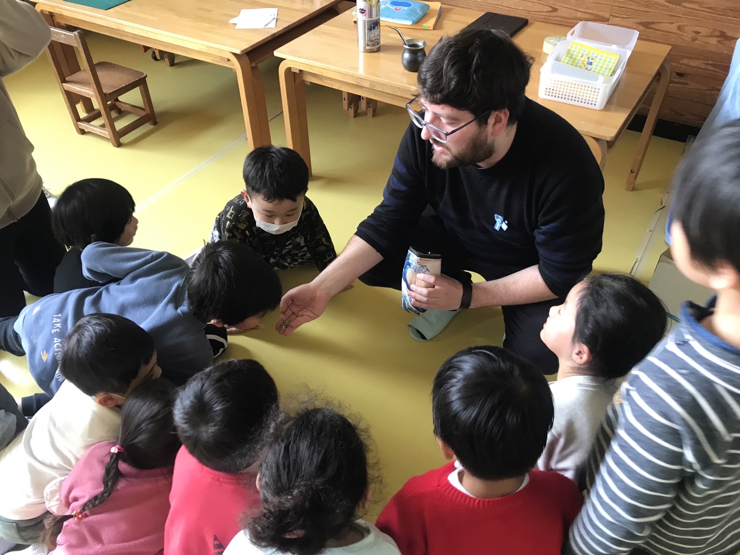 La imagen muestra a Pablo en un aula,  junto a niños japoneses 