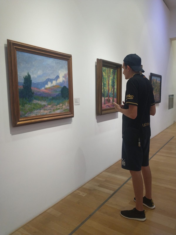 La imagen muestra a un estudiante tomando una foto a un cuadro en el Museo Nacionald de Bellas Artes