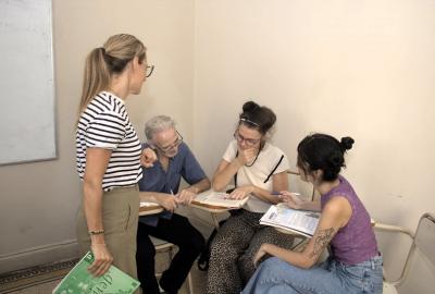 La imagen muestra un aula del Laboratorio de idiomas con una profesora y estudaintes