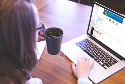 mujer mirando computadora con taza de té