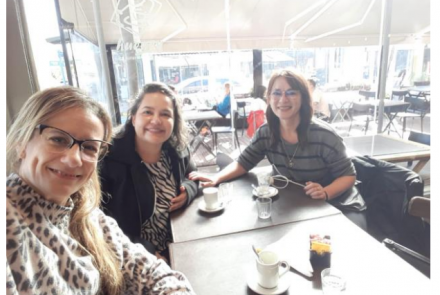 La imagen muestra a las profesoras mencionadas en el artículo sentadas frente a la mesa de un bar