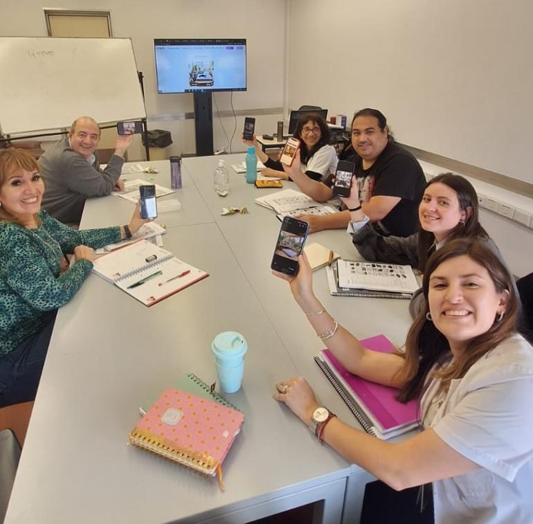 La imagen mestra una clase de idiomas en el Hospital Garrahan, estudiantes y profesor alrededor de una mesa